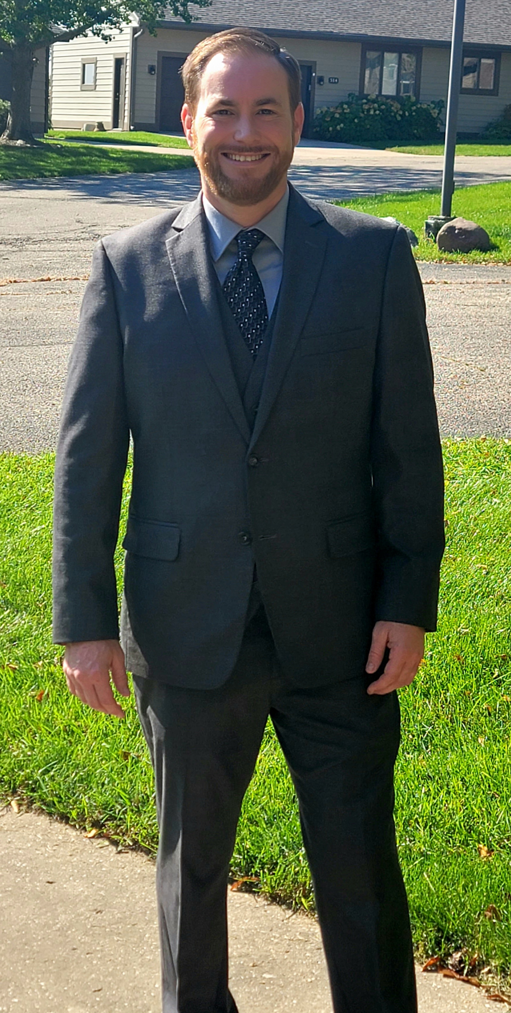 Paul Gover smiling outdoors in a dark suit and tie