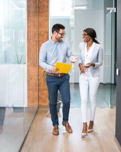 Coworkers walking together through an office, with the floor visible