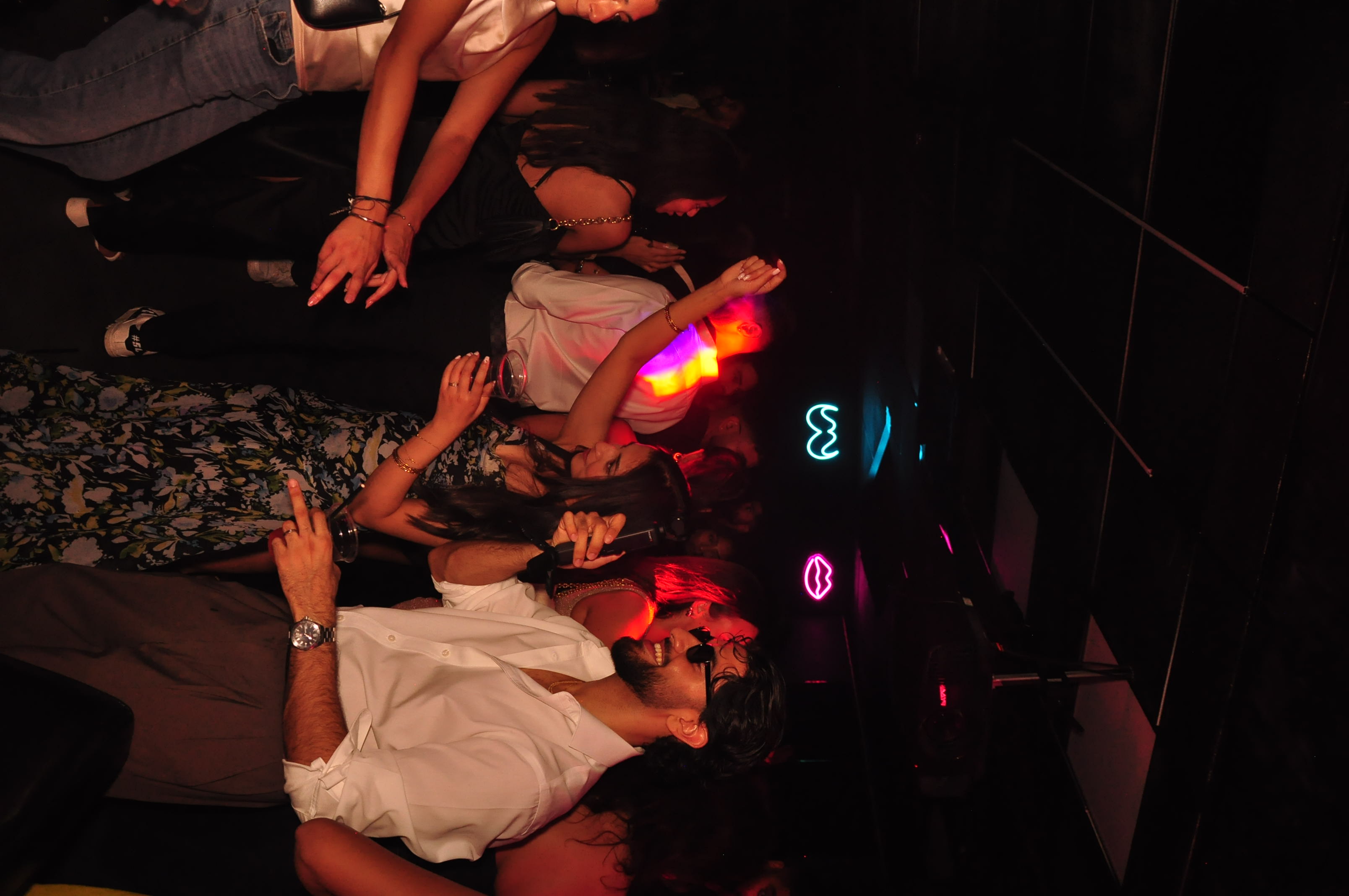 Friends dancing beneath neon lights