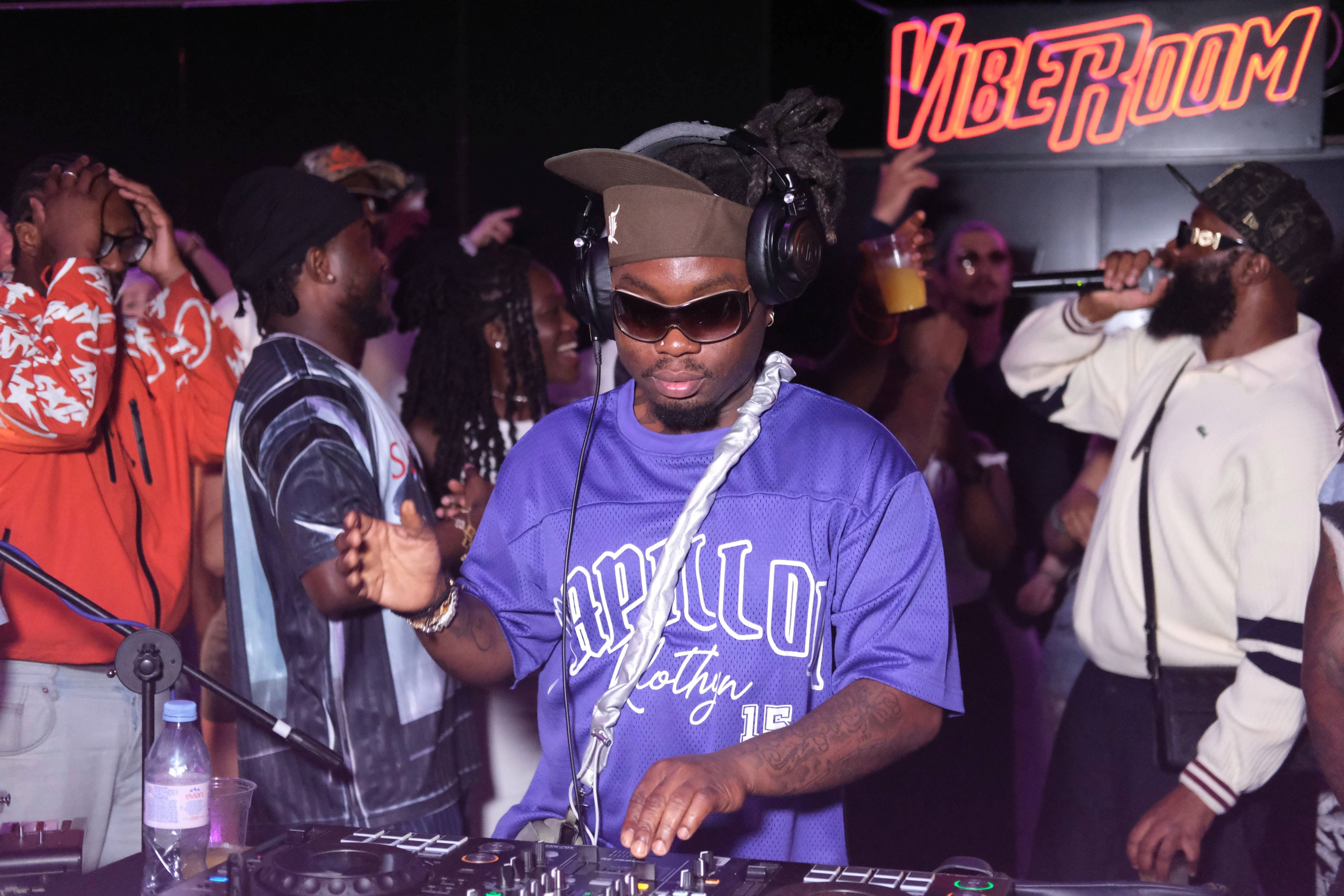 DJ performing for a crowd under neon lights