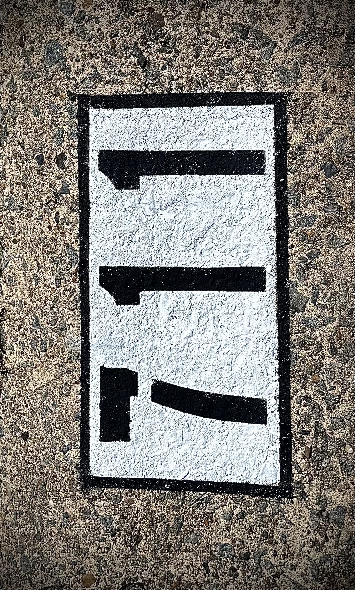 Decorative border curb number painting — black numbers on white fill with clean black rectangular border on concrete curb