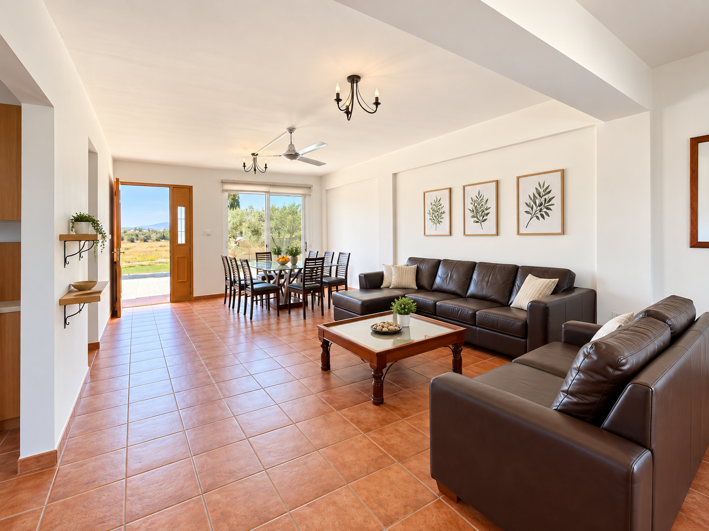 A bright living area with sofas, a coffee table and dining table