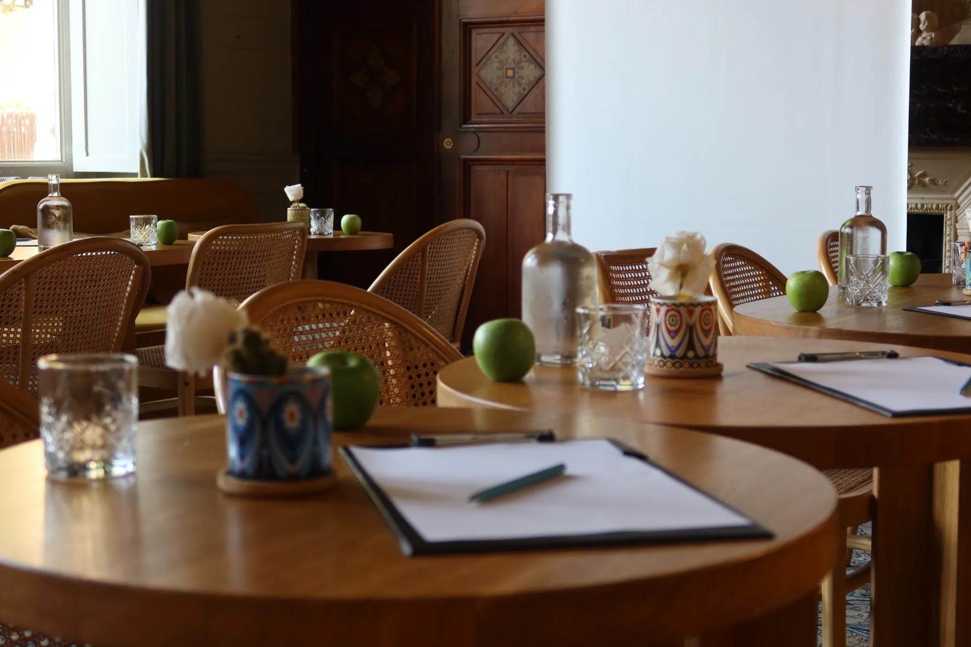 Le salon en format séminaire : tables rondes, blocs-notes, carafes d'eau et pommes vertes