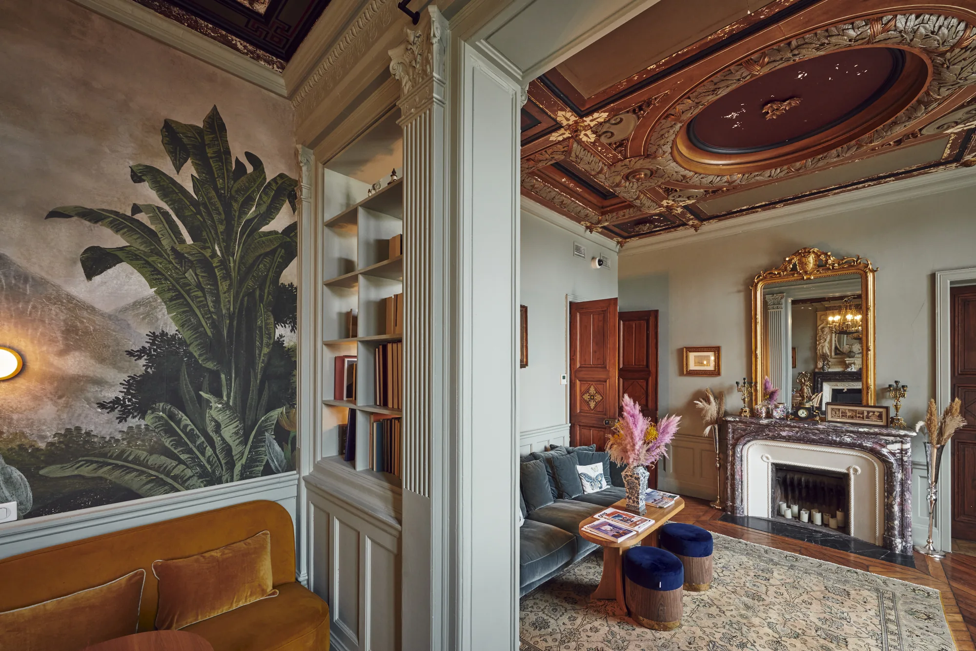Depuis l'entrée, les portes de bois ouvertes sur la bibliothèque et le salon