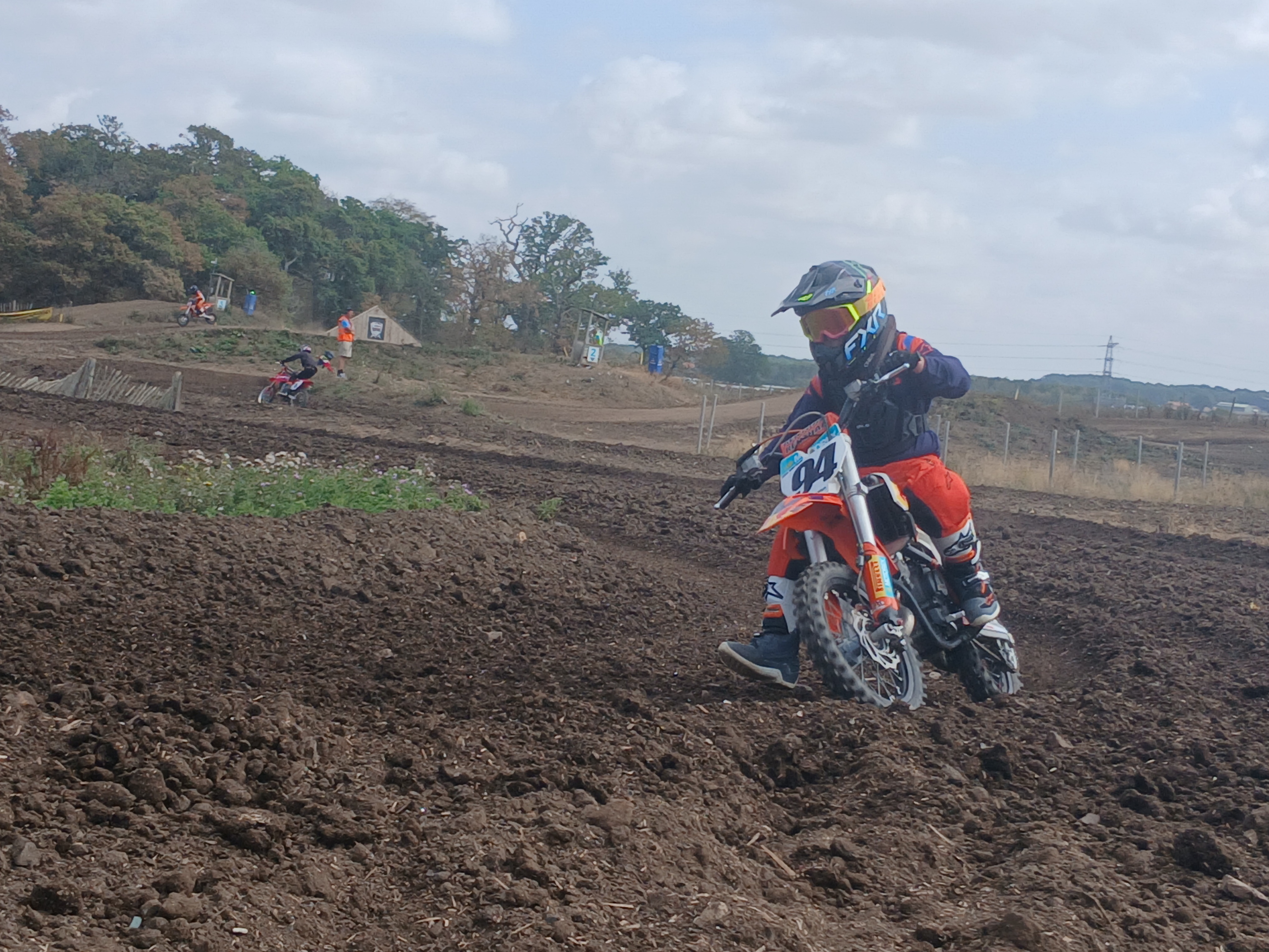 A motocross rider carving through a muddy track on a dirt bike.